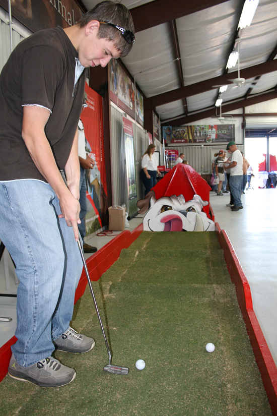 A visitor at the 33rd annual Sunbelt Agricultural Exposition Oct. 19 takes a putt at the University of Georgia building, where the university highlighted its world-famous turfgrass research program. Most southeastern golf courses and many football fields are planted in a turf developed by UGA.