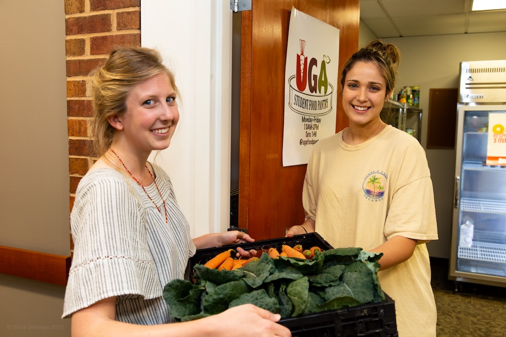 UGArden intern Lily Dabbs, a second-year geography major working toward a certificate in urban and metropolitan studies, delivers the first crop of UGArden vegetables to Ava Parisi, UGA Student Food Pantry director and a student majoring in health promotion and behavioral medicine. Photo by Vince Selvidge.