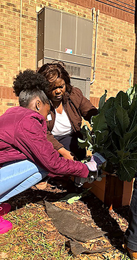 Sumter County 4-H Agent Crystal Perry helps a student care for the plants in the garden bed as part of the ROCKETS program.