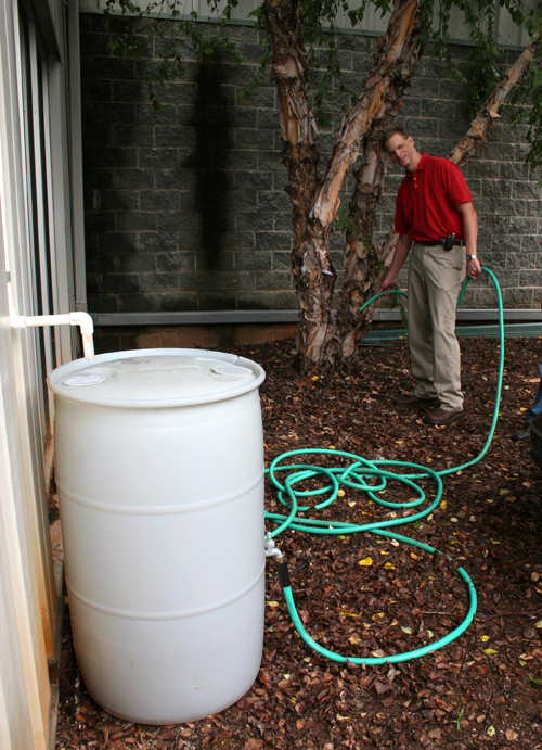 Frank Henning shows how a rain barrel can be used for irrigation. From small sizes like this one to larger harvesting systems, using rain water can save homeowners money and help the environment.