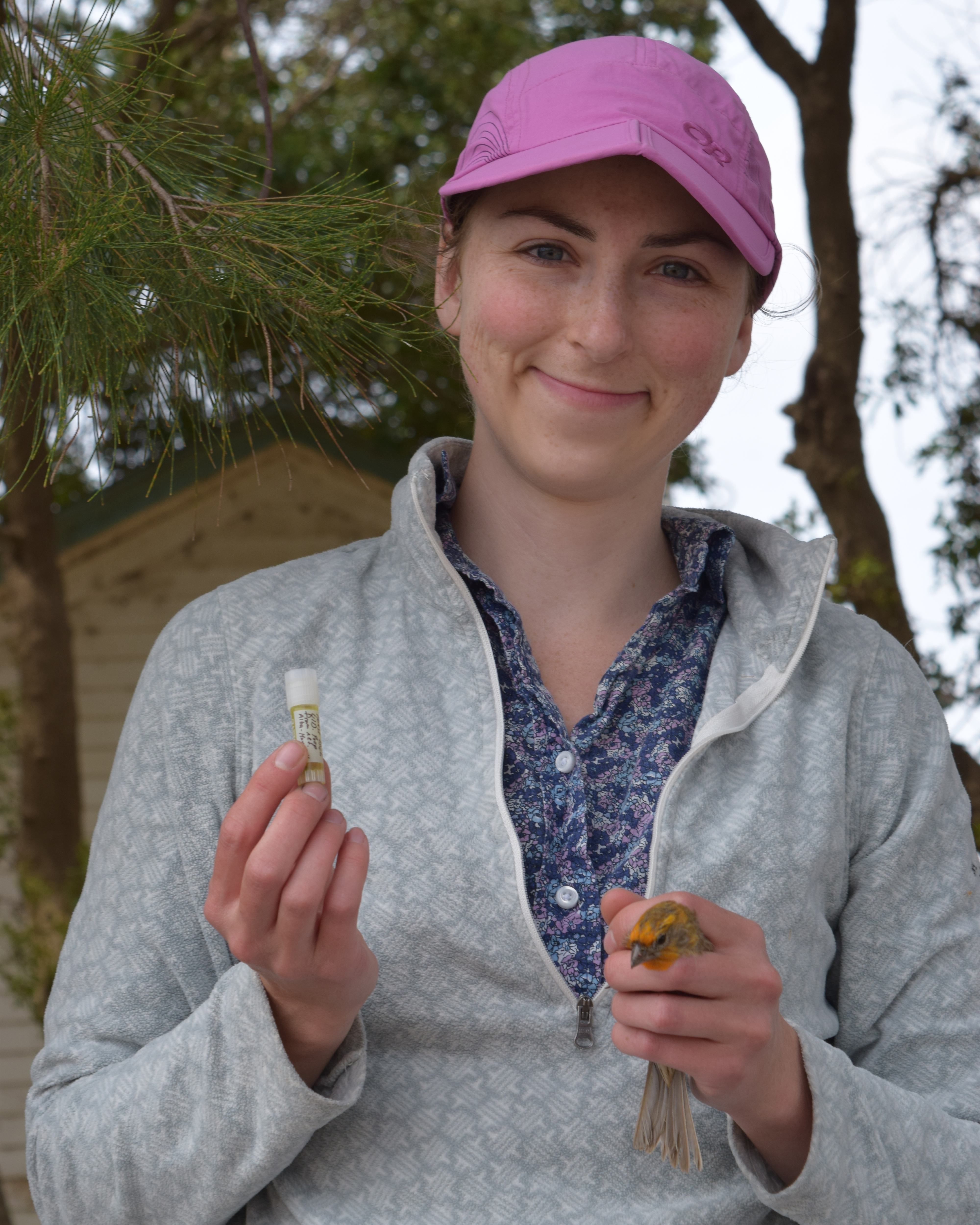 Smith posing with a bird and a research sample.