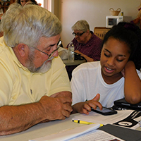 Tech Changemaker youth leader Elena demonstrates Facebook basics to her partner during the one-on-one help session at the Murray County Senior Center in October 2019.
