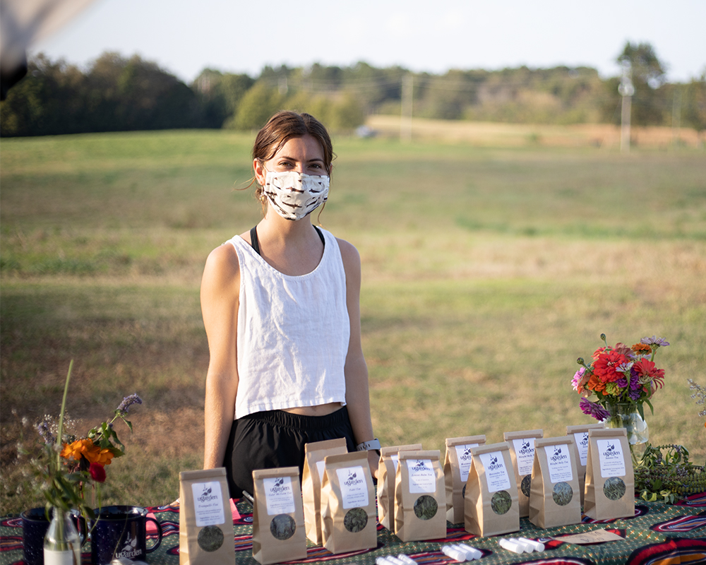 Erica Head, a student in the Organic Horticulture Entrepreneurship class and student assistant herb manager at UGArden, sells teas from herbs she's grown and processed at a weekly student farmers market.