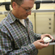 Wayne Parrott, a crop and soil sciences professor at the University of Georgia College of Agricultural and Environmental Sciences, examines an agar plate with just-formed soybean plants.