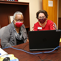 Leigh Anne Aaron (right), a UGA Cooperative Extension agent serving Morgan and Oconee counties, assists Oconee County resident Hallie Adams with tax preparation as part of the UGA Volunteer Income Tax Assistance Program.