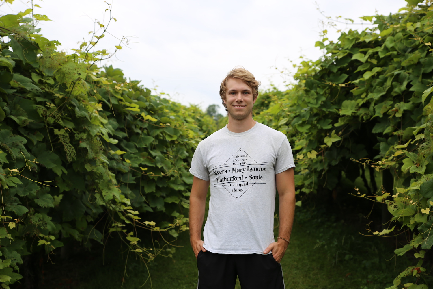 Trent Sutton stands in the foreground with vines at his back at Tiger Mountain Vineyards.