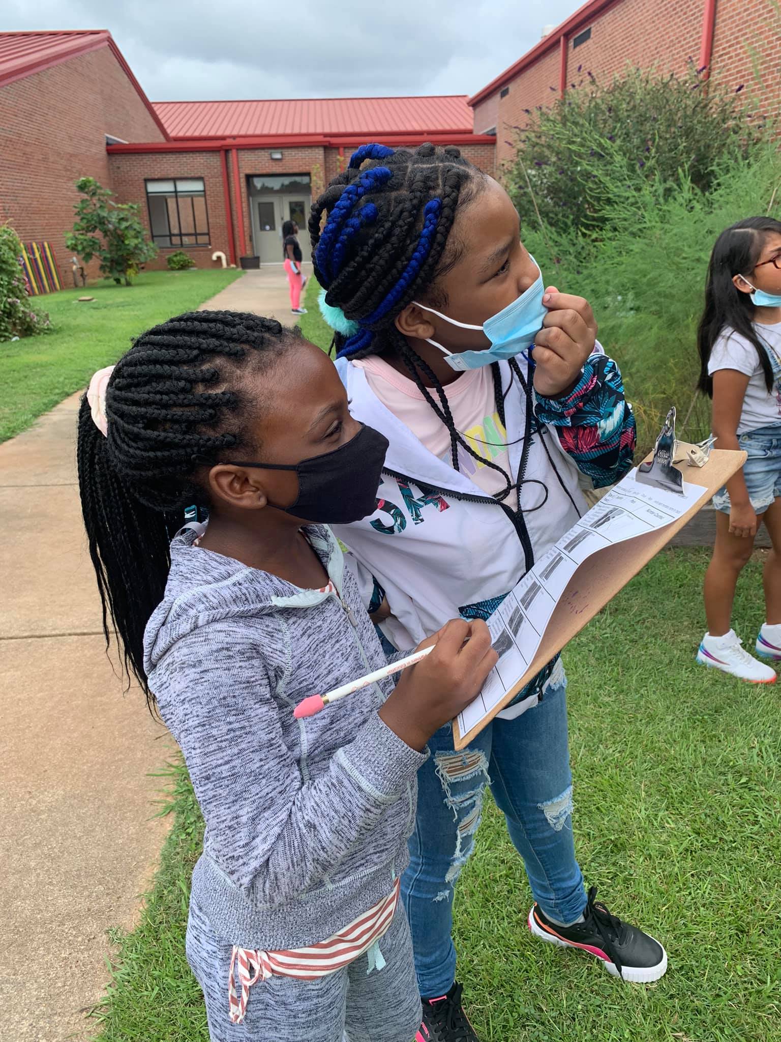 A woman and girl wear masks while participating in the pollinator census