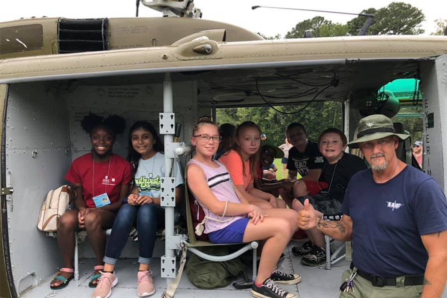 4-H'ers from Ben Hill County get a tour of a Vietnam War-era helicopter from a member of the Army Aviation Heritage Foundation in Hampton, Georgia, at the Mission Make-It event.
