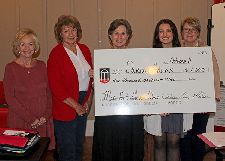 Members of the Marie Fort Garden Club award UGA-Griffin student Darian Adams with giant white check made out for $1K.