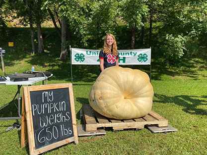 Senior 4-H’er Maggie Payne poses with her first-place winning 650-pound pumpkin at the Union County Extension Office. 