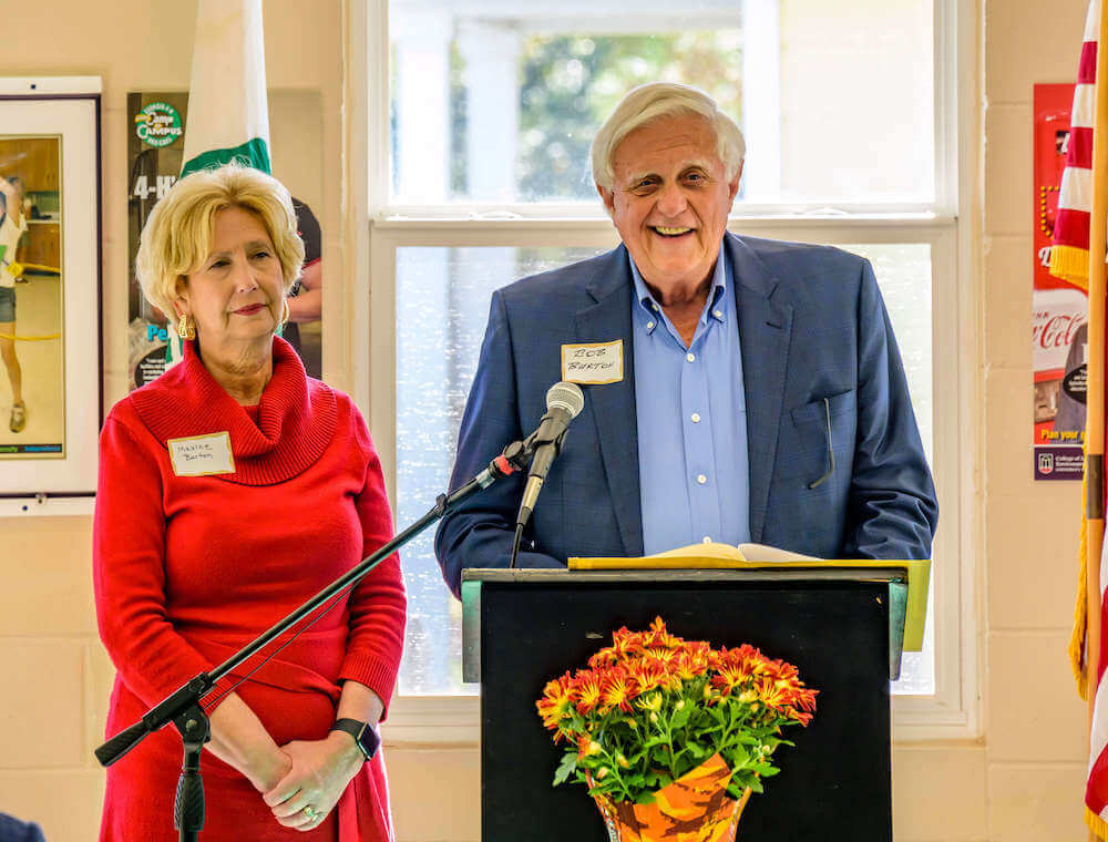 Maxine and Bob Burton speak at a lectern at the 75th anniversary of the Burton 4-H Center.