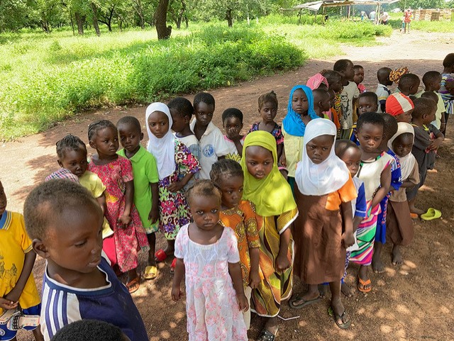 Ghanaian school children wait for their daily school meal