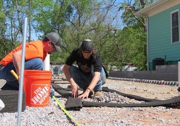 Members of the Elite Radon Team install a radon mitigation system at a house in Athens.