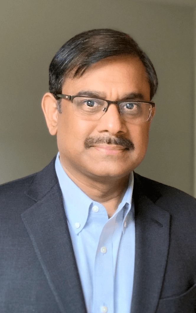 Gopi Munisamy wears a dark suit and stands against a gray background in his professional headshot