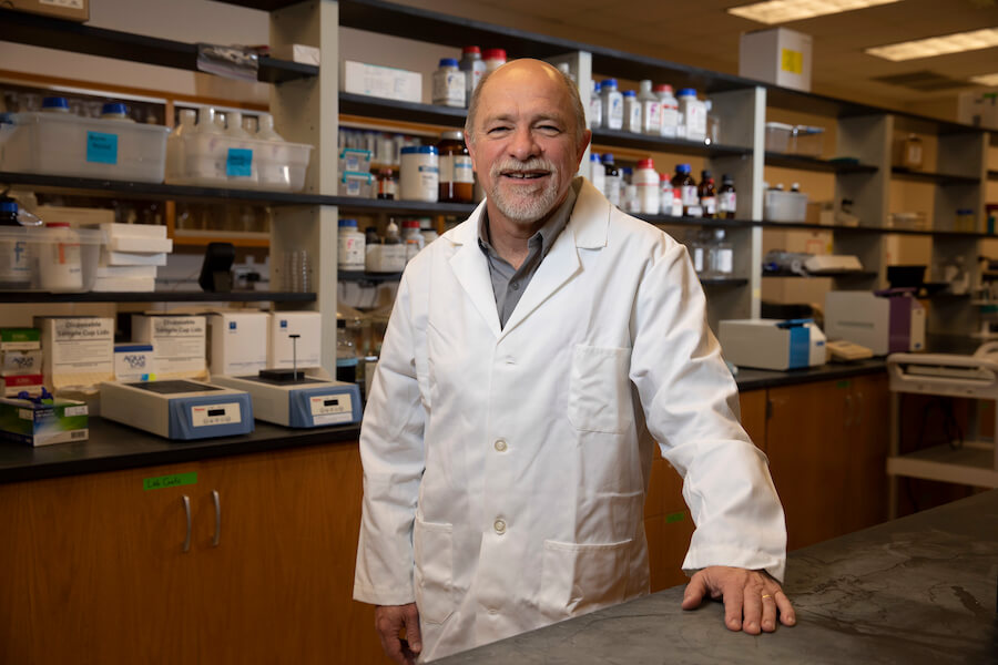 Francisco Diez-Gonzalez, director of the University of Georgia’s Center for Food Safety, stands in his lab wearing a lab coat.