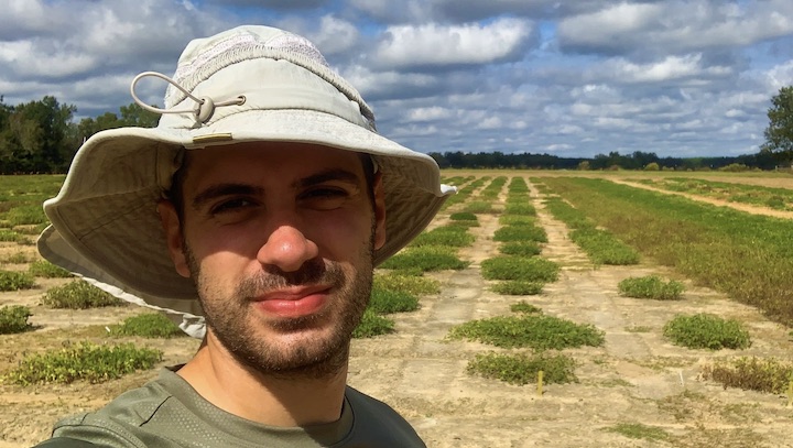 Samuele Lamon stands in field where peanuts are grown.