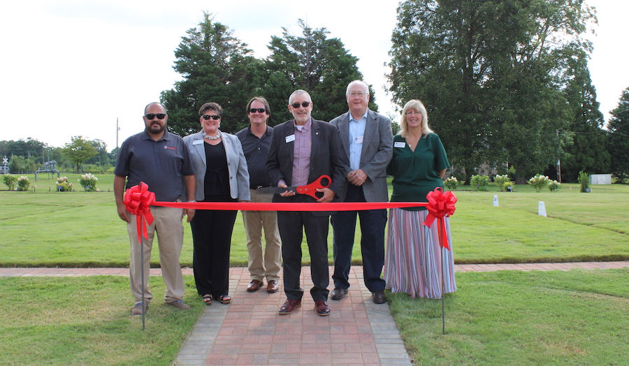 A group of leaders at CAES and UGA-Griffin prepare to cut the ribbon at the Irrigation Demonstration Site at UGA-Griffin. CAES Dean Nick Place holds the oversized pair of red scissors.