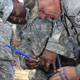 Command Sergeant Major Tony Willis practices using a pill popper to dispense medicine to a sheep while Tech Sergeant Kody Jorgensen holds the ewe. Drs. Will Getz and Seyedmehdi Mobini of Fort Valley State University helped UGA agricultural experts train the Georgia National Guardsmen for a mission in Afghanistan.