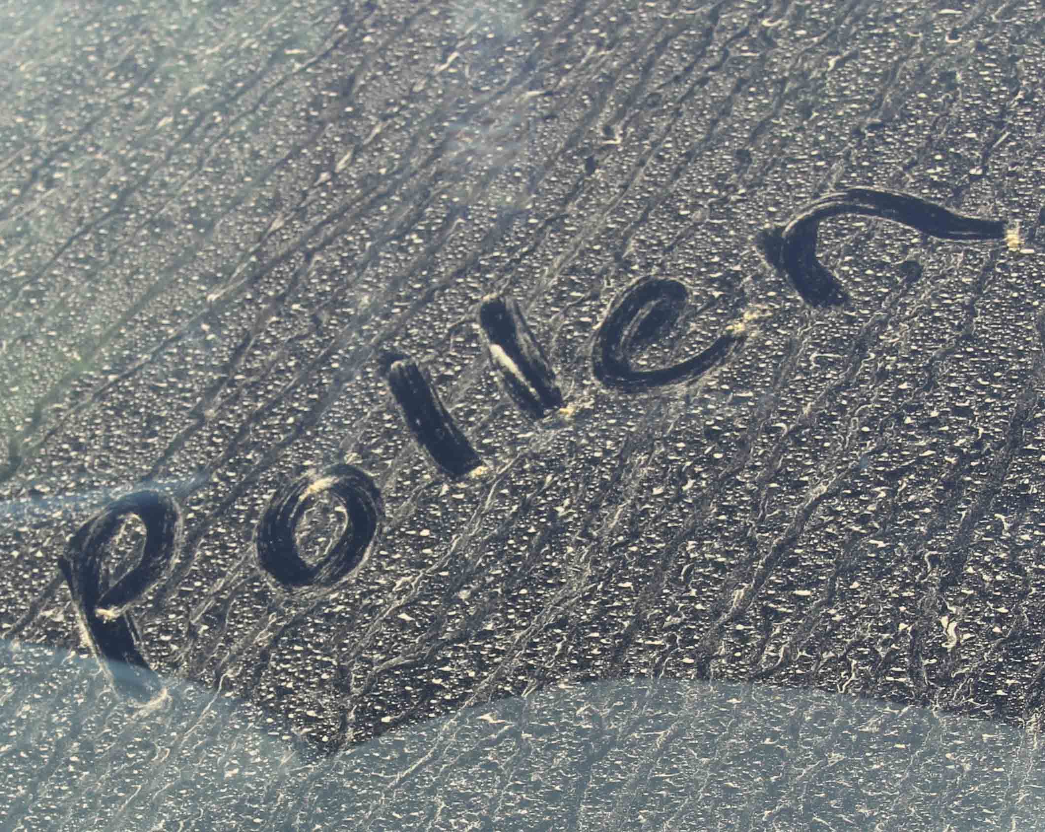 A photo of a car windshield covered with yellow pine pollen.