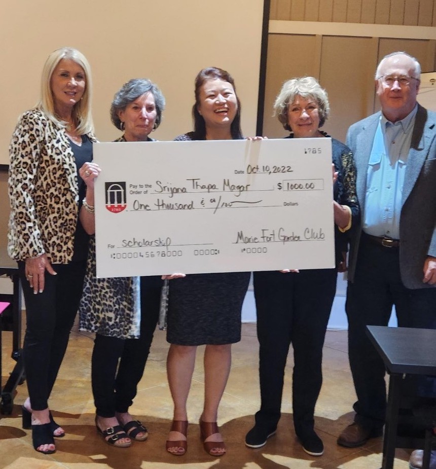 The garden club and UGA-Griffin campus director David Buntin pose with the scholarship winner and a giant check.