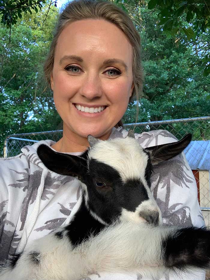 UGA Extension Leadership Specialist Lauren Griffeth holds a small black and white lamb.