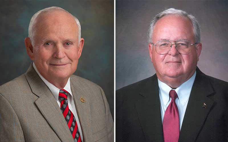 Raybon Anderson on the wearing a neutral colored suit with a red and black striped tie, John Callaway on the right in a charcola colored suit with a maroon tie.