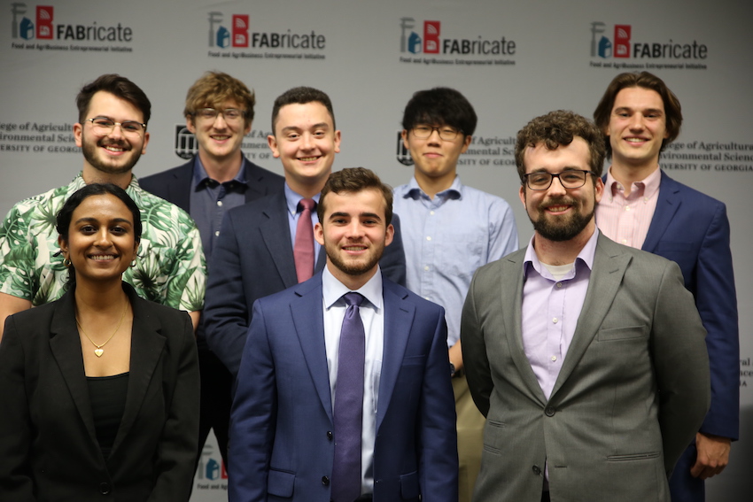 The 2023 FABricate finalists pose for a photo against a FABricate logo backdrop.