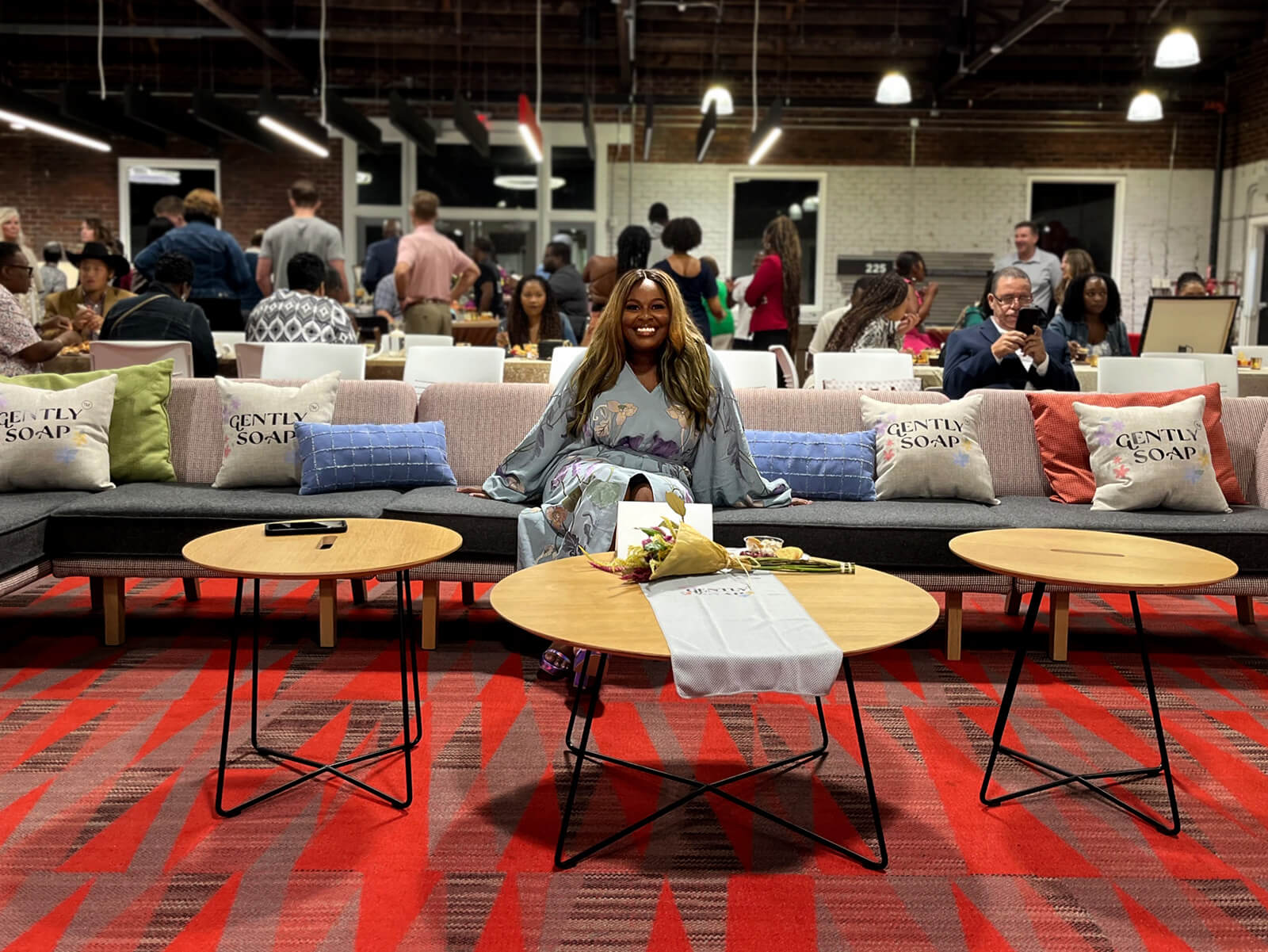 Kristen Dunning poses on the sofa at a UGA watch party for her appearance on Shark Tank.