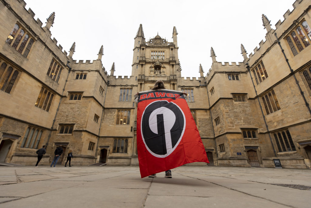 Undergraduate student Carolina Pinckney holds a Georgia flag in the courtyard of the Bodelian Library in Oxford, U.K. (Photo by Andrew Davis Tucker/UGA)