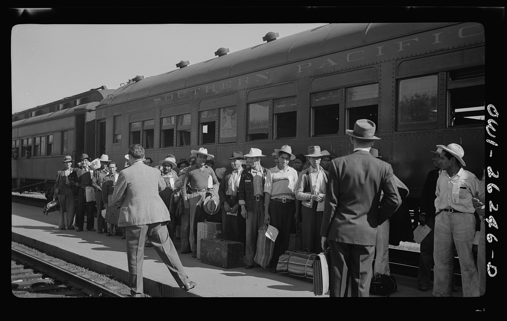 Migrant workers wait in line to board a train in this historical photo