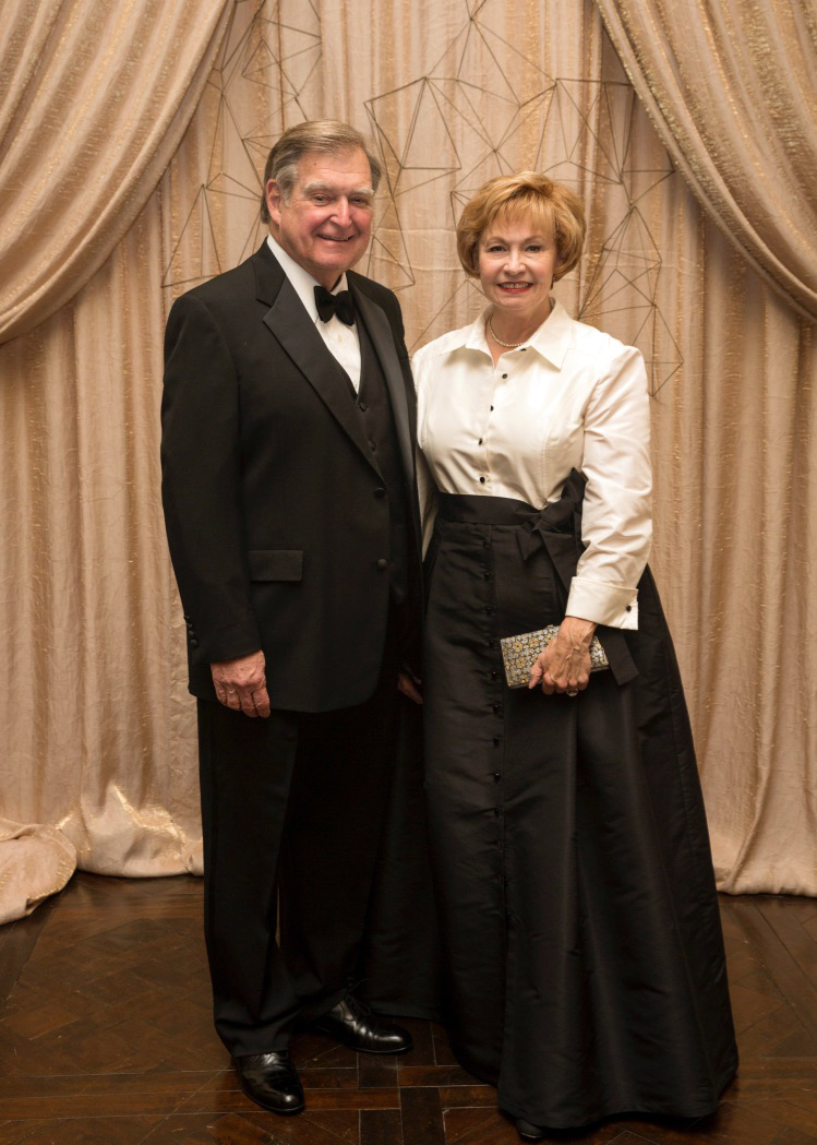 A man and a woman in formal attire stand for a photo.
