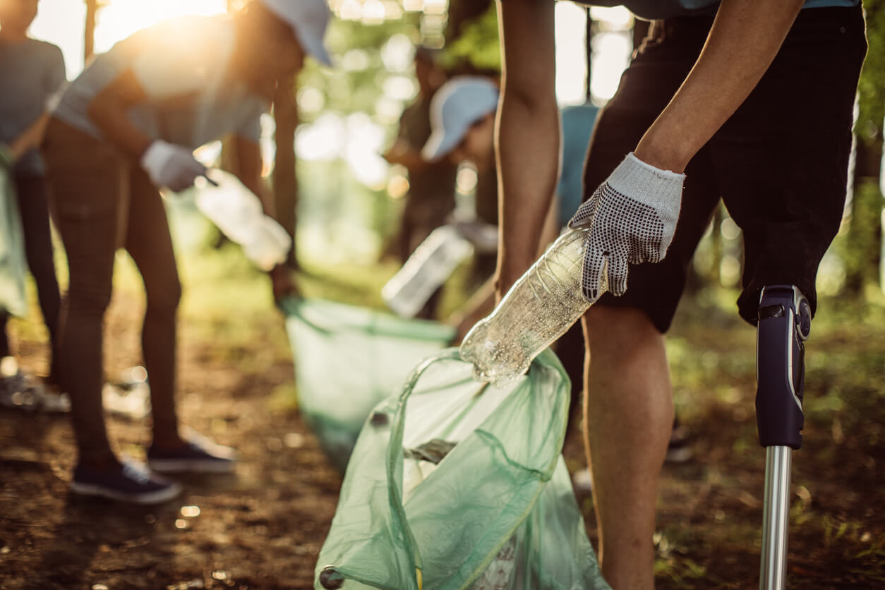 Group of volunteers with garbage bags cleaning park area