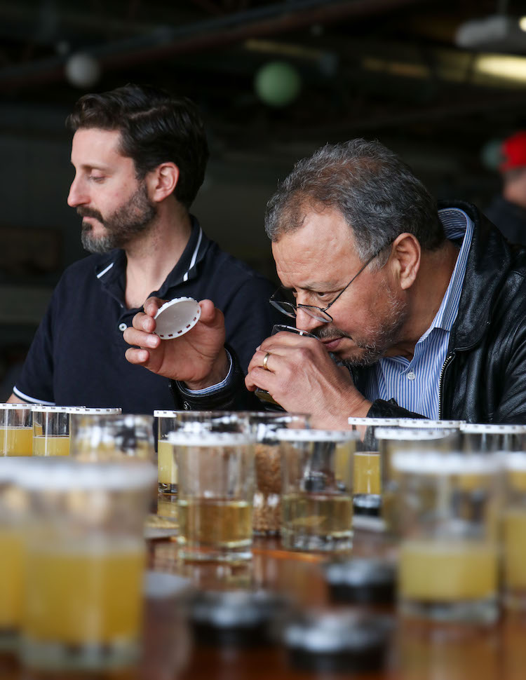 UGA Professor Mohamed Mergoum lifts a glass to his nose to smell a test brew during a blending lab at Creature Comforts Brewing Co.