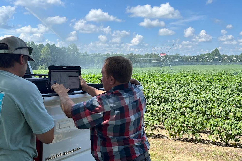 Jason Mallard demonstrates soil moisture sensor technology with farmer